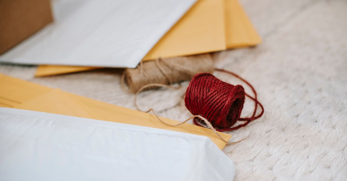 Thick woolen threads placed among paper envelopes for sending mail on textured textile